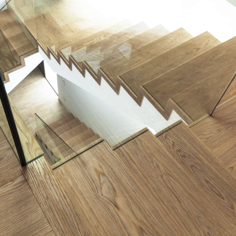 Referenzbild: Betonblocktreppe in Eiche mit Glasgeländer
